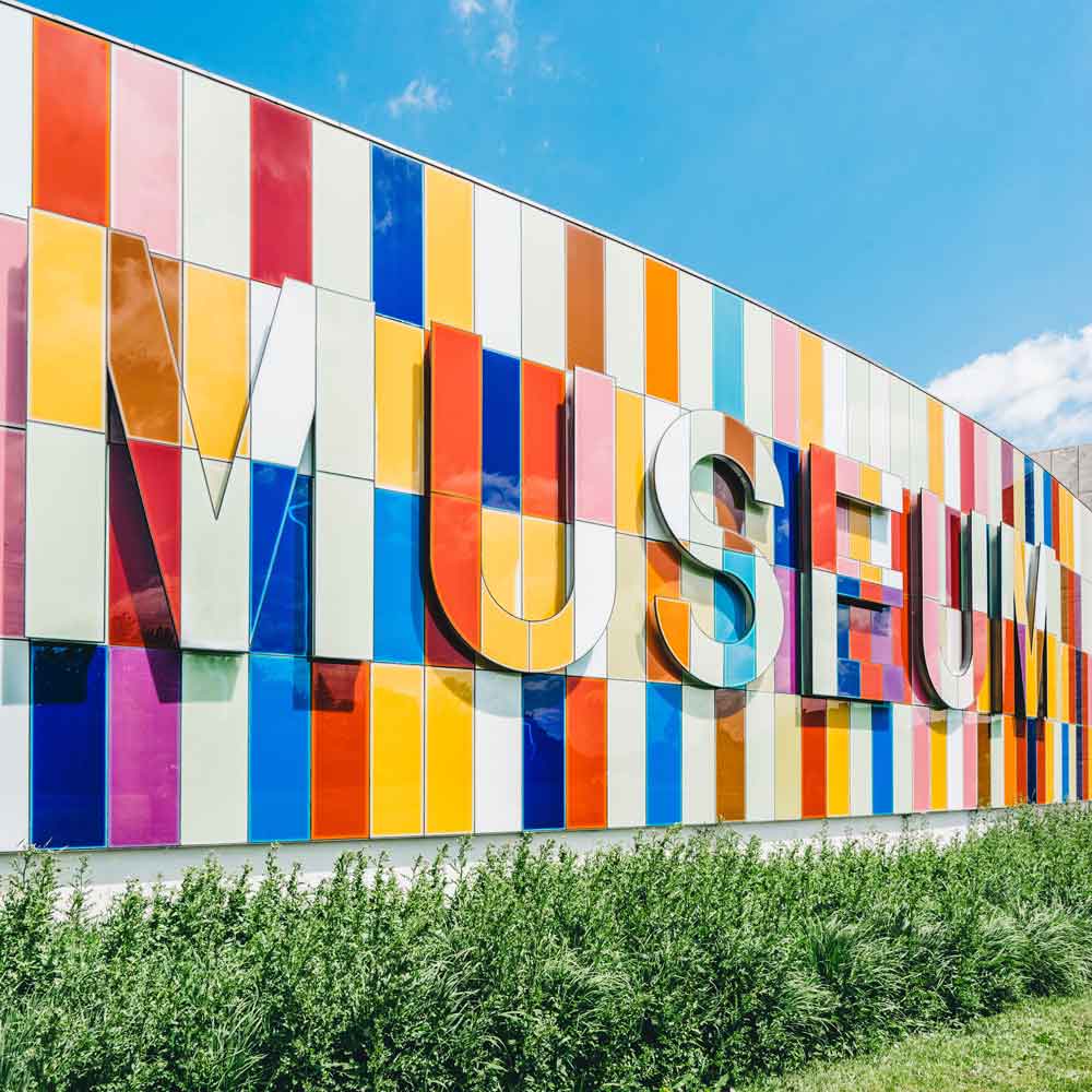 A wall with Museum writen on it in different colors